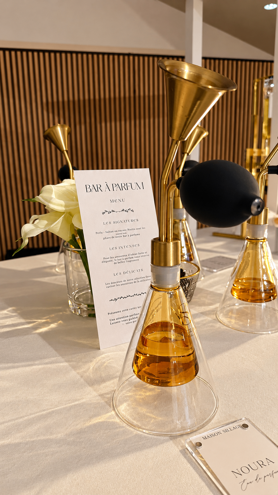 Diffuseurs vintage à poire noire et menu du bar à parfum sur un comptoir