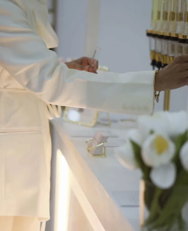 Une invitée découvre le bar à parfum et ses distributeurs dorés